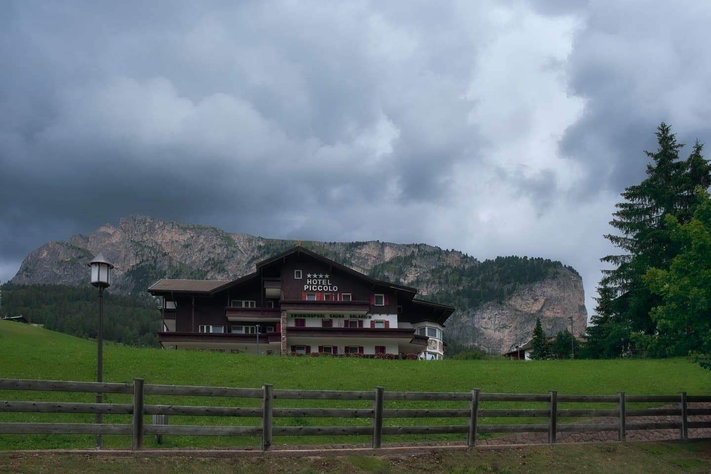 L'Hotel Piccolo si trova su una collina erbosa di fronte a montagne rocciose.