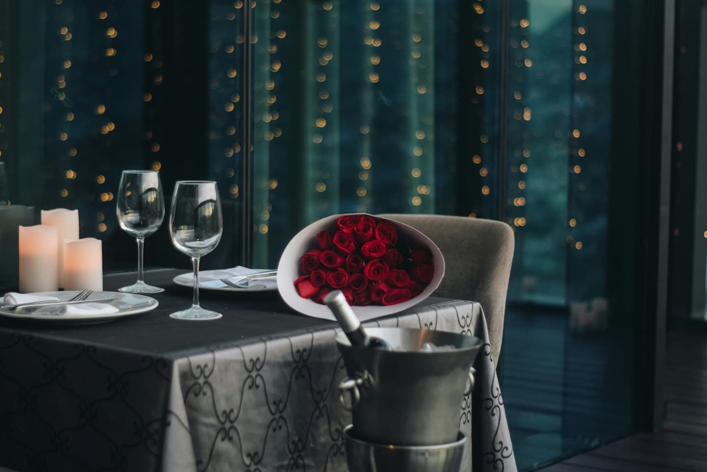 Una tavola apparecchiata per una cena romantica per due con vino e rose.